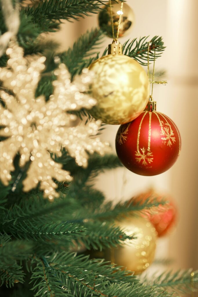 Close-up of a decorated Christmas tree with red and gold ornaments and a snowflake.